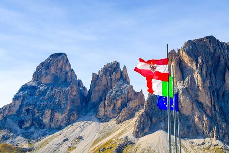 Flags of Austria, Italy and European Union with Dolomites Mountains in background, Italyの写真素材