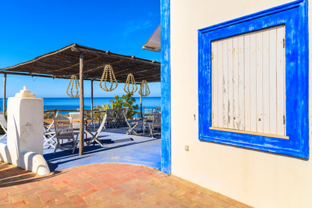 PORTIMAO TOWN, PORTUGAL - MAY 15, 2015: Tables on terrace in small coastal restaurant with sea view near Portimao town. Algarve region is most popular tourist destination in Portugal.のeditorial素材