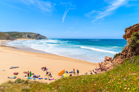 PRAIA DO AMADO BEACH, PORTUGAL - MAY 15, 2015: Surfers relaxing on sandy beach on sunny beautiful day. Water sports are popular activity in this region of the country.のeditorial素材