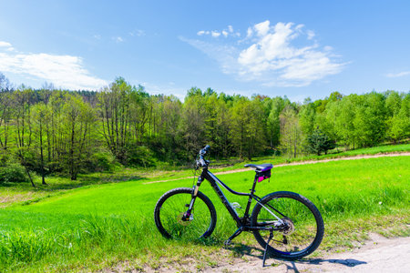 VISTULA RIVER CYCLING TRACK, POLAND - APR 28, 2018: Mountain bike parking on road near Alwernia village during spring sunny day. Cycling lane along Vistula river is located nearby.のeditorial素材