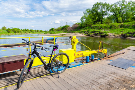 VISTULA RIVER, POLAND - APR 28, 2018: Mountain bike parking on ferry transporting it across Vistula river during spring sunny day. Cycling is very popular activity among Poles.のeditorial素材
