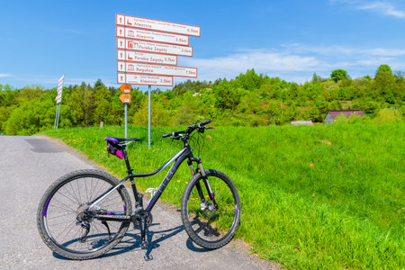 VISTULA RIVER CYCLING TRACK, POLAND - APR 28, 2018: Mountain bike parking on road near Alwernia village during spring sunny day. Cycling lane along Vistula river is located nearby.のeditorial素材