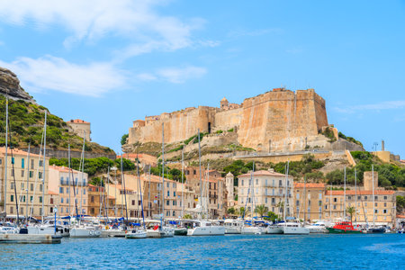 BONIFACIO PORT, CORSICA ISLAND - JUN 25, 2015: sailing yacht boats anchoring in Bonifacio port with citadel building in background. It is famous old town built on top of a cliff.のeditorial素材