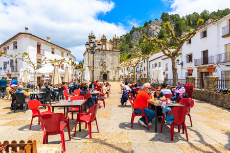 GRAZALEMA TOWN, SPAIN - MAY 12, 2018: Tourists eating lunch on church square in typical Andalusian village of Grazalema which is one of most visited white towns in Southern Spain.のeditorial素材