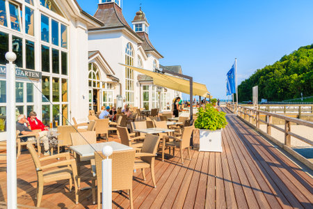SELLIN, RUEGEN ISLAND - MAY 31, 2018: People relaxing on restaurant terrace on pier in Ostseebad Sellin on Baltic Sea coast, Germany. Ruegen is popular tourist destination due to its architecture.のeditorial素材