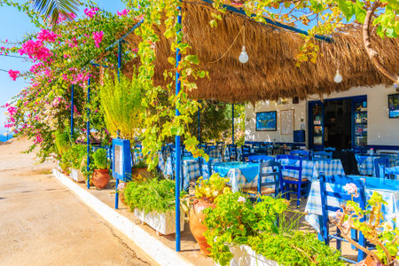 LEFKOS VILLAGE, KARPATHOS ISLAND - OCT 1, 2018: Terrace with tables in traditional Greek tavern decorated with flowers in Lefkos village on Karpathos island, Greece.のeditorial素材