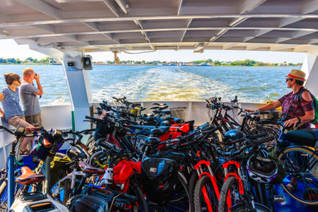 SCHAPRODE PORT, RUGEN ISLAND - MAY 30, 2018: Tourists transporting bicycles on board of ferry from Hiddensee island to Rugen island, Baltic Sea, Germany.のeditorial素材