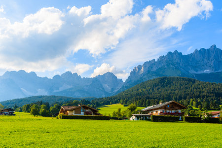 Traditional alpine houses on green meadow in village of Going am Wilden Kaiser on beautiful sunny summer day, Tirol, Austriaのeditorial素材