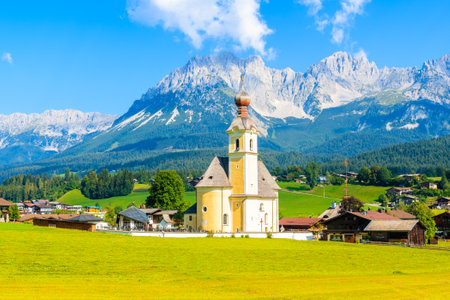 Church on green meadow in Going am Wilden Kaiser village on beautiful sunny summer day, Tirol, Austriaのeditorial素材