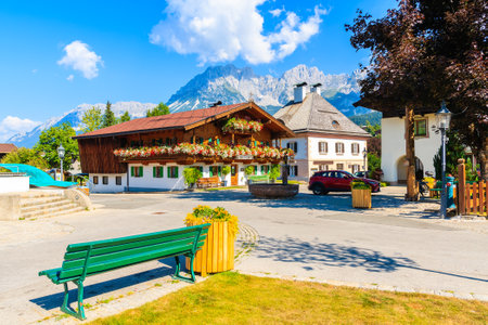 Traditional alpine houses on square in village of Going am Wilden Kaiser on beautiful sunny summer day with Alps mountains in background, Tirol, Austriaのeditorial素材