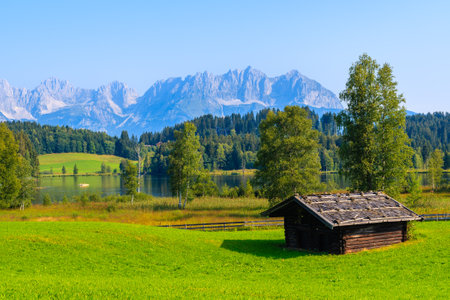 Typical alpine old wooden hut on green meadow near Schwarzsee lake lake on sunny summer day, Tirol, Austriaのeditorial素材