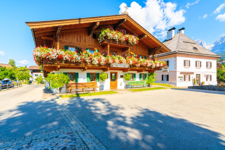 TIROL, AUSTRIA - JUL 29, 2018: Water fountain and houses on square in beautiful alpine village of Going am Wilden Kaiser on sunny summer day, Tirol, Austria.のeditorial素材
