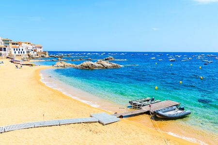 Dinghy boats on amazing beach in Calella de Palafrugell, scenic fishing village with white houses...