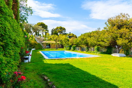 TOSSA DE MAR, SPAIN - JUN 3, 2019: Swimming pool in garden of luxury house in Tossa de Mar town, Costa Brava, Spain.のeditorial素材
