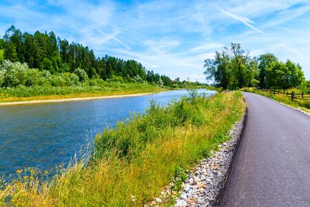 Cycling way along Dunajec river and green fields near Czorsztynskie lake and Nowy Targ, Tatra...