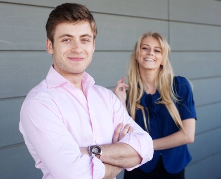 portrait of a young businessman with a businesswoman in the backgroundの写真素材