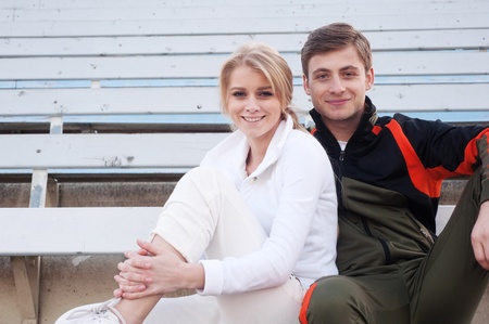 happy male and female athletes sitting in the bleachersの写真素材
