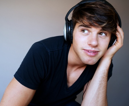 portrait of young man with headphones listening to music in a studioの写真素材