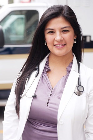 Portrait of young female doctor standing in front of an ambulanceの写真素材