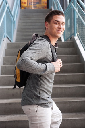 young male college student at school with backpack