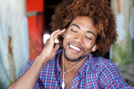 closeup portrait of a handsome African American man at the beach listening to musicの写真素材