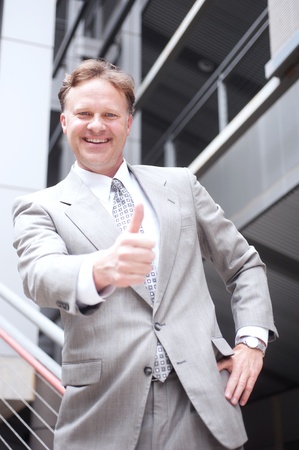 portrait of a confident mature businessman standing outside with arms foldedの写真素材