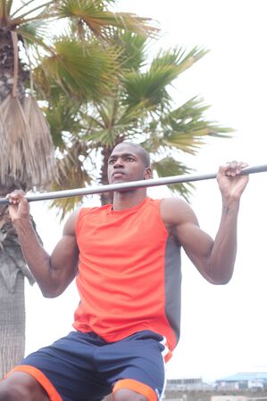 portrait of an African American athlete doing pullups outdoors