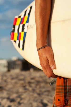 closeup shot of a surfer holding a surfboard at the beachの写真素材