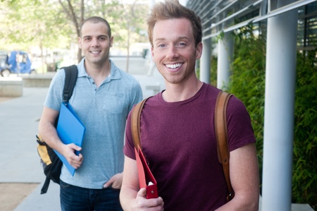 pair of happy young male students on campus