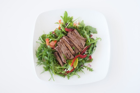 plate of fresh chopped steak salad on white backgroundの写真素材