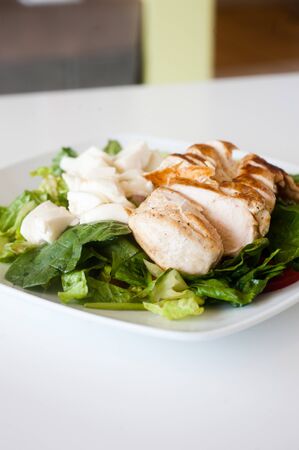 plate of fresh chopped grilled chicken salad on a white backgroundの写真素材