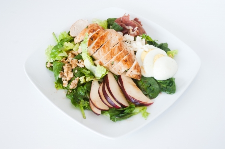 plate of fresh chopped grilled chicken salad on a white backgroundの写真素材