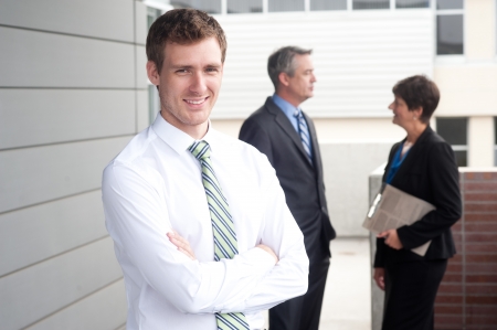 portrait of a handsome young businessman standing outside officeの写真素材