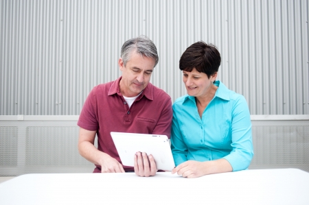 elderly couple sitting, on the tablet computerの写真素材