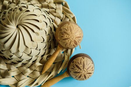 Vacation souvenirs. Hat and maracas from palm leaves on blue background with copy space for textの写真素材