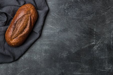 Rustic bread on dark background with copy space. Flat lay. Handmade.