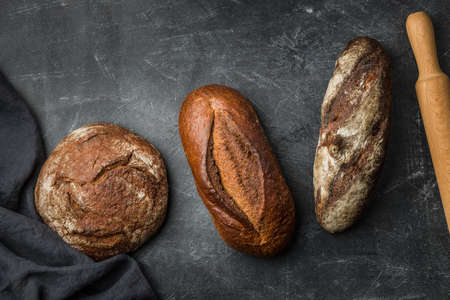 Rustic bread on dark background. Flat lay.の写真素材