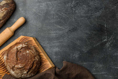 Rustic bread of whole wheat grains on dark background with copy space. Flat lay.の写真素材