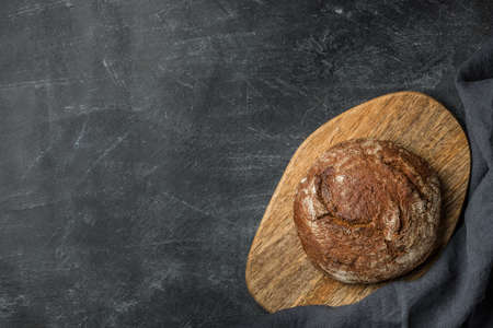 Rustic bread on dark background with copy space. Flat lay. Handmade.の写真素材