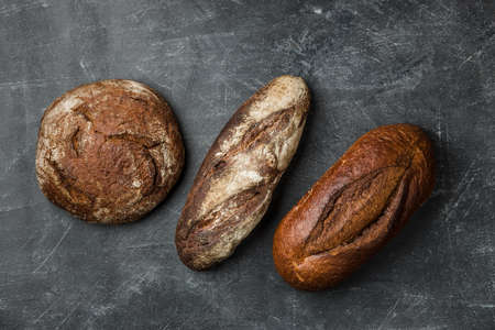 Rustic bread on dark background. Flat lay.の写真素材