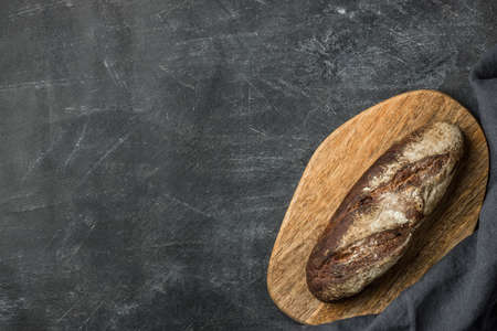 Rustic bread on dark background with copy space. Flat lay. Handmade.の写真素材