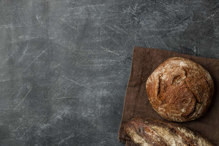 Rustic bread of whole wheat grains on dark background with copy space. Flat lay.の写真素材