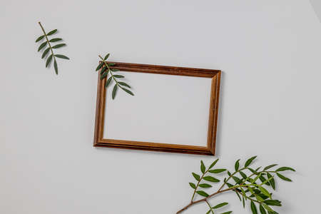 Empty brown wood border, with craft paper and green branches isolated on white table background. Summer wedding stationery mock-up scene. Feminine Mediterranean top view, flat lay.の写真素材