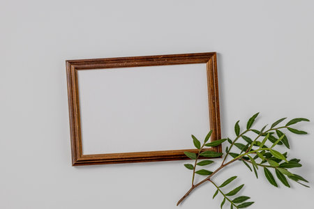 Empty brown wood border, with craft paper and green branches isolated on white table background. Summer wedding stationery mock-up scene. Feminine Mediterranean top view, flat lay.の写真素材