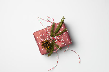 gift box decorated with fir branches and cones on a white backgroundの写真素材