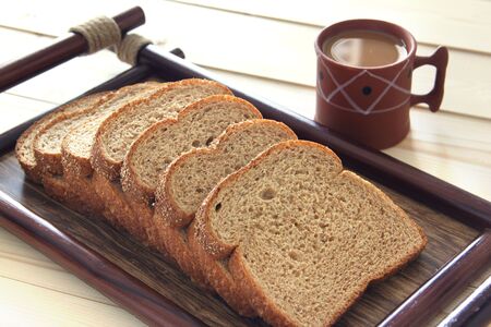 Tray of bread with coffee placed on a patio tableの写真素材