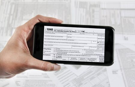 Filing taxes online using a mobile phone and internetの写真素材