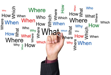 Person writing common questions on a white boardの写真素材