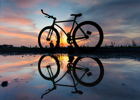 silhouette of a bicycle at sunsetの写真素材