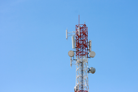 Communications tower with antennas on blue skyの写真素材